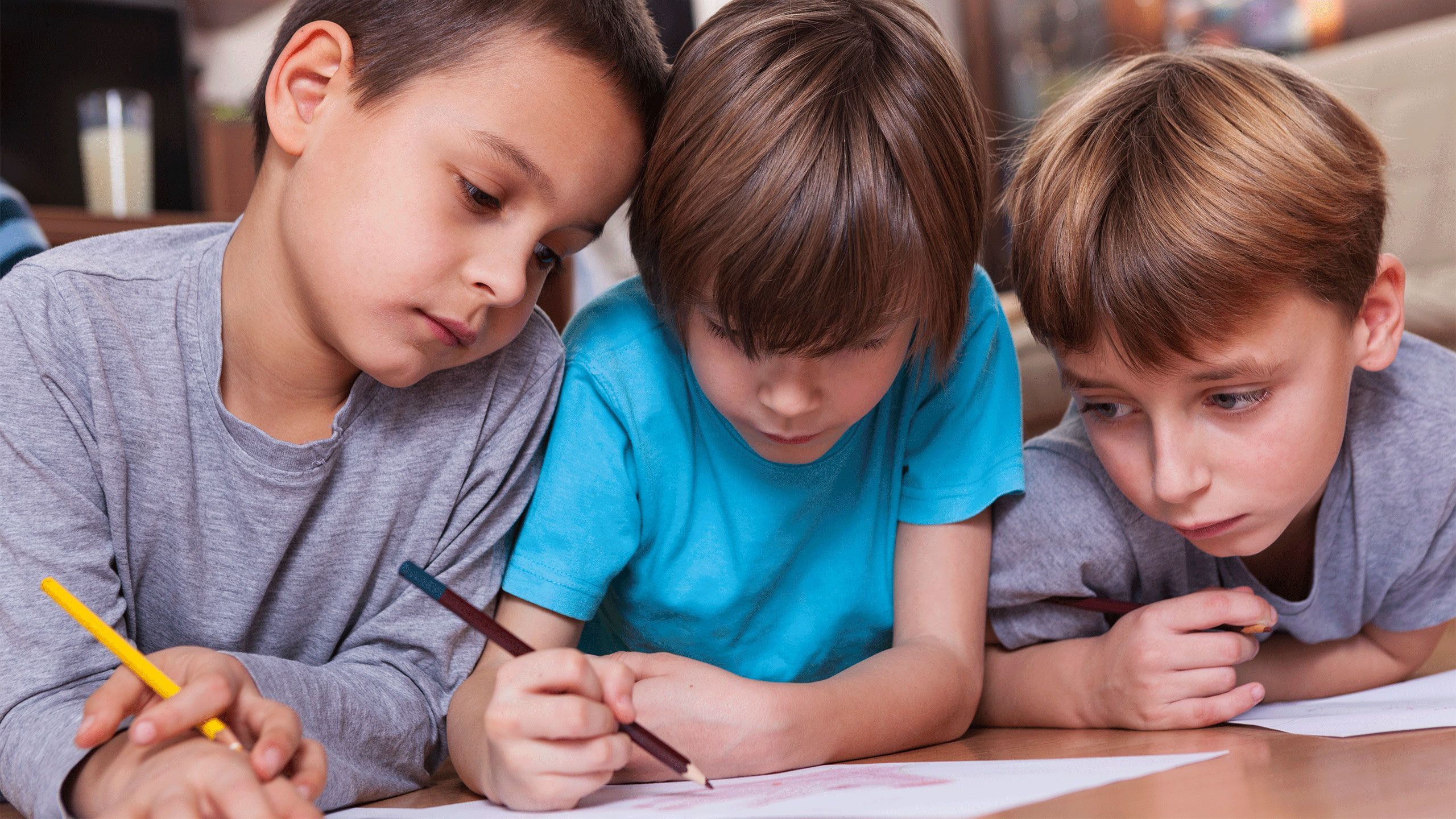 Three children writing together.