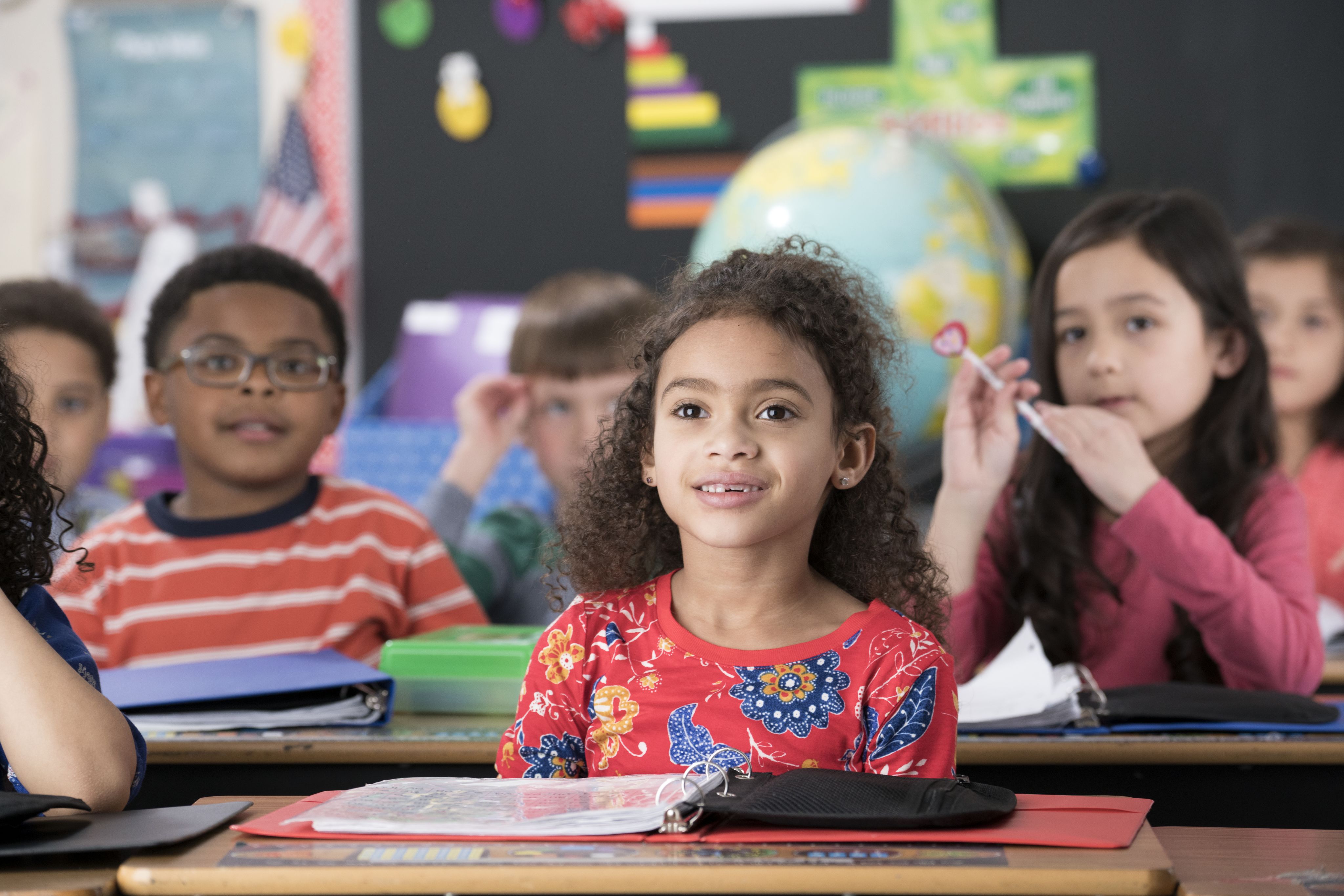 Child sitting in class and looking in wonder