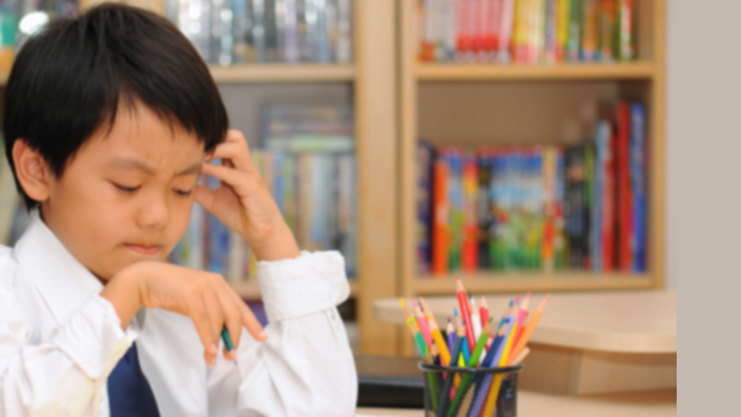 Image of young student concentrating very hard on piece of written work.